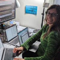 Paula in green sweater sitting at desk