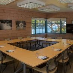 North Bay room with tables set up in a square, monitor screen in background